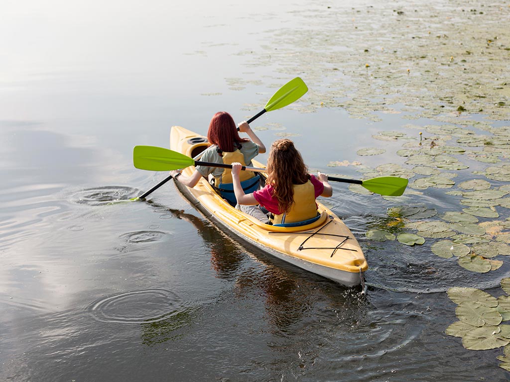 women-rowing-kayak-lake